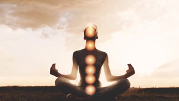 person meditating with activated chakras at peace