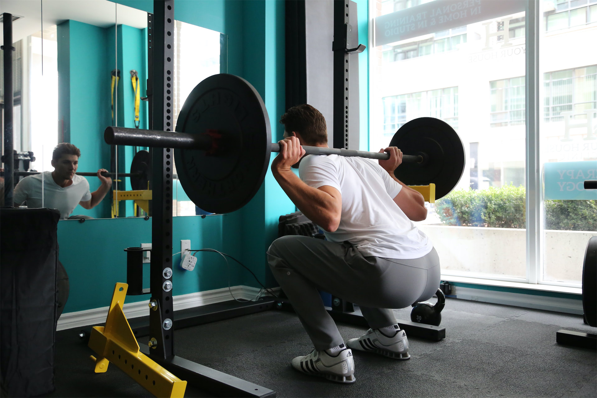 man weight training doing squats